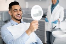 歯科医院で鏡を見て歯を確認する男性