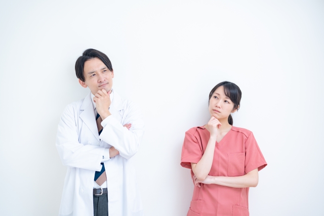 歯ならびが悪くなった時のリスクについて考えている男性歯科医師と女性歯科医師